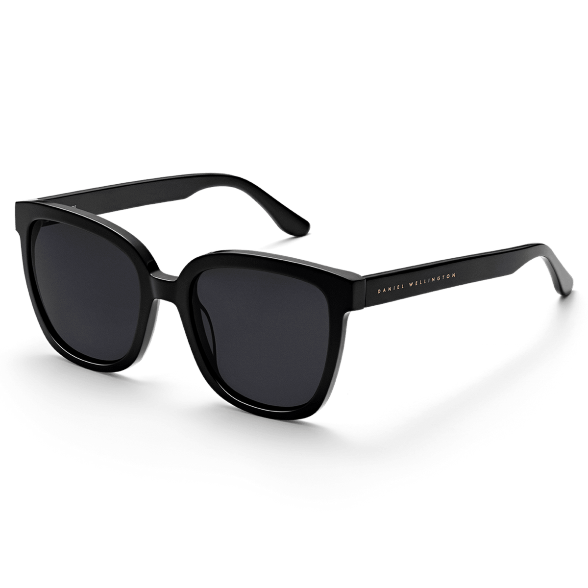 Grande Bio-Acetate Black sunglasses with a bold, oversized square frame in glossy black, featuring dark lenses and subtle Daniel Wellington branding on the temple.
