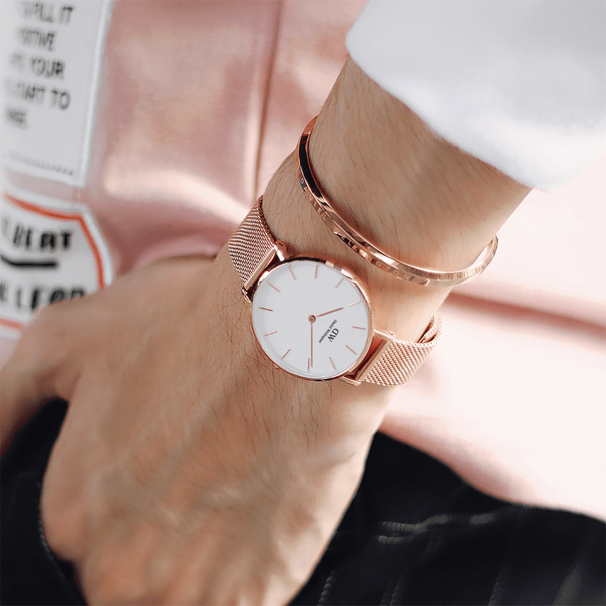 Classic Bracelet Rose Gold by Daniel Wellington worn on the wrist with a matching rose gold mesh watch, showcasing its slim, adjustable cuff design and understated elegance suitable for everyday wear.