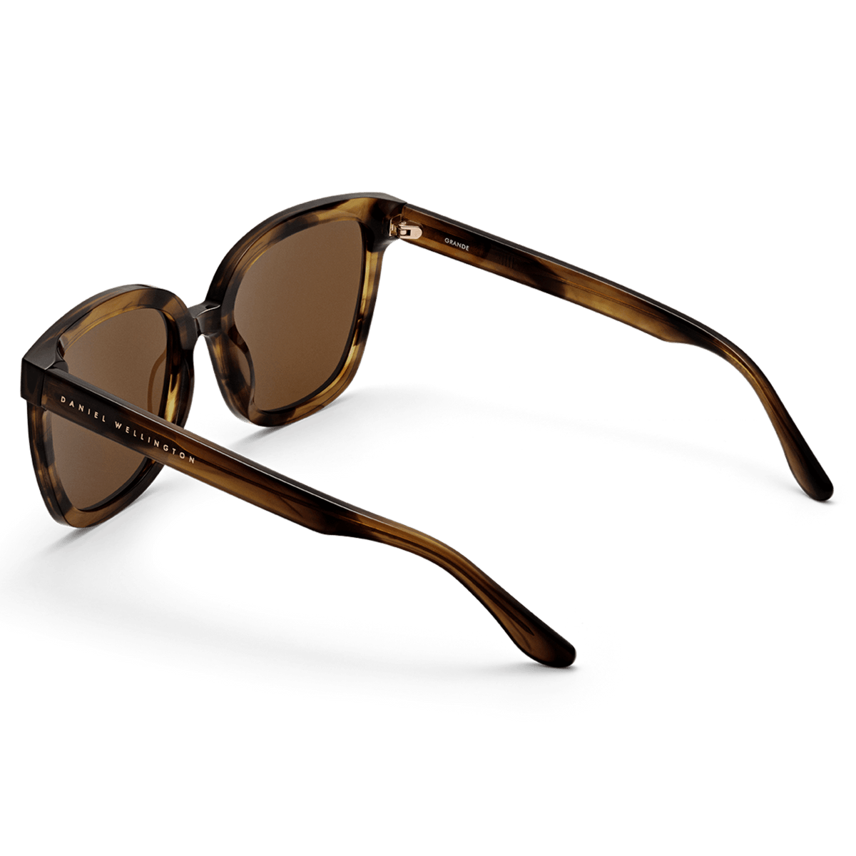 Grande Bio-Acetate Brown Demi sunglasses featuring a brown demi patterned frame, amber lenses, and Daniel Wellington branding on the temples, shown from a rear angle to highlight the lightweight construction and smooth finish.