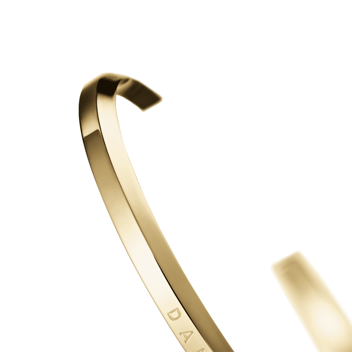 Detail view of the Classic Bracelet Gold showing the curved, polished gold cuff and part of the engraved Daniel Wellington logo, emphasising its minimalist structure and smooth finish.