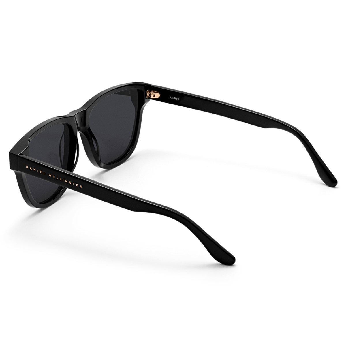 Ambler Bio-Acetate Black sunglasses with a modern classic shape, featuring a glossy black Italian bio-acetate frame, dark UV400 lenses, and the Daniel Wellington logo on the arm.