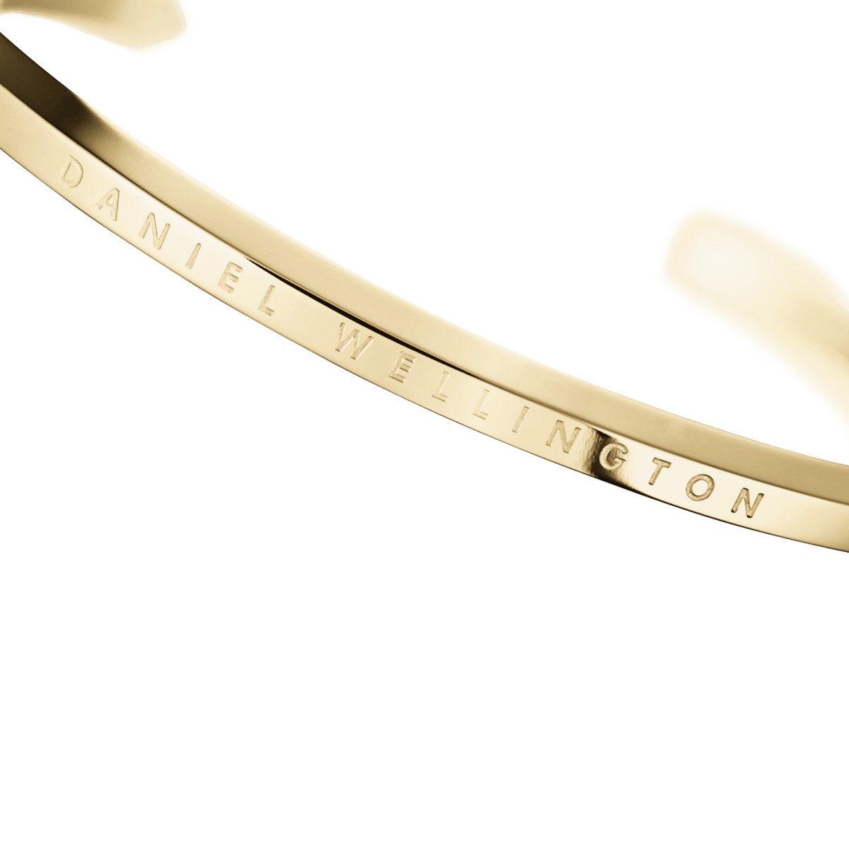 Close-up of the Classic Bracelet Gold showing the engraved Daniel Wellington logo on the polished gold cuff, highlighting its refined finish and minimalist design.