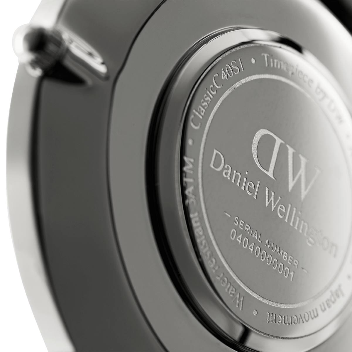 Close-up of the Classic St Mawes Black Silver watch case back, highlighting the engraved Daniel Wellington branding, water resistance details, and unique serial number.