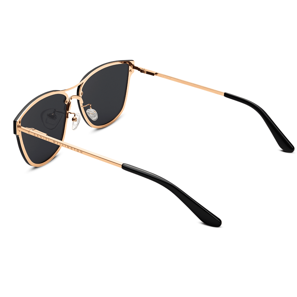 Ambler Steel Rose Gold sunglasses with a softly rounded rose gold plated stainless steel frame, dark nylon lenses, and black cellulose acetate temple tips, shown from an angled rear view to highlight the adjustable silicone nose pads and slim arms.