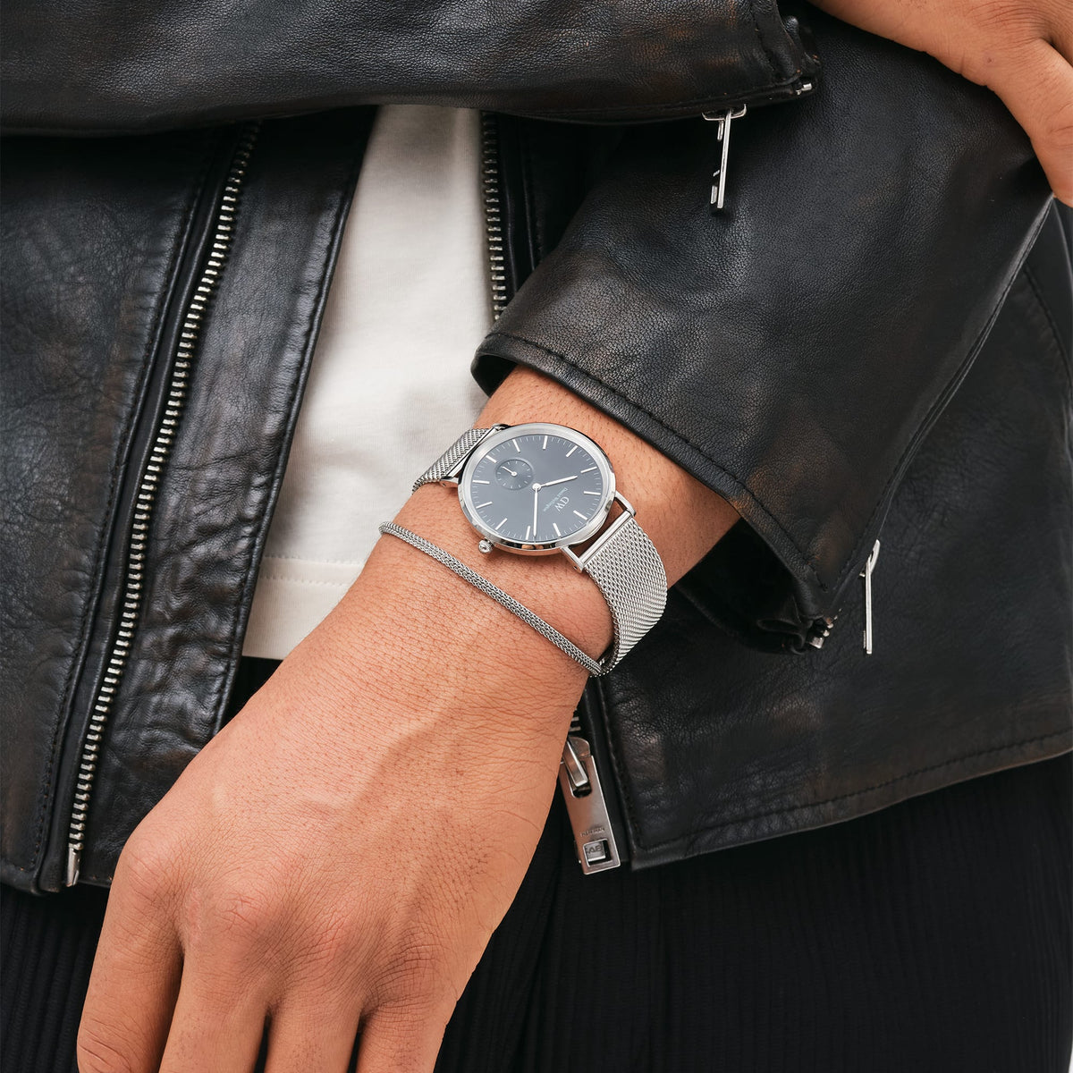 Classic Multi-Eye Sterling Onyx men's watch with a black dial and silver mesh strap, worn on the wrist alongside a silver bracelet and styled with a black leather jacket for a modern, versatile look.