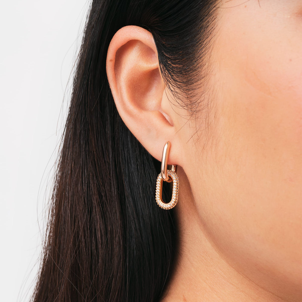 Crystal Link Earrings Rose Gold worn on the ear, showcasing the chunky rose gold plated link with sparkling cubic zirconia crystals and a refined, modern finish.