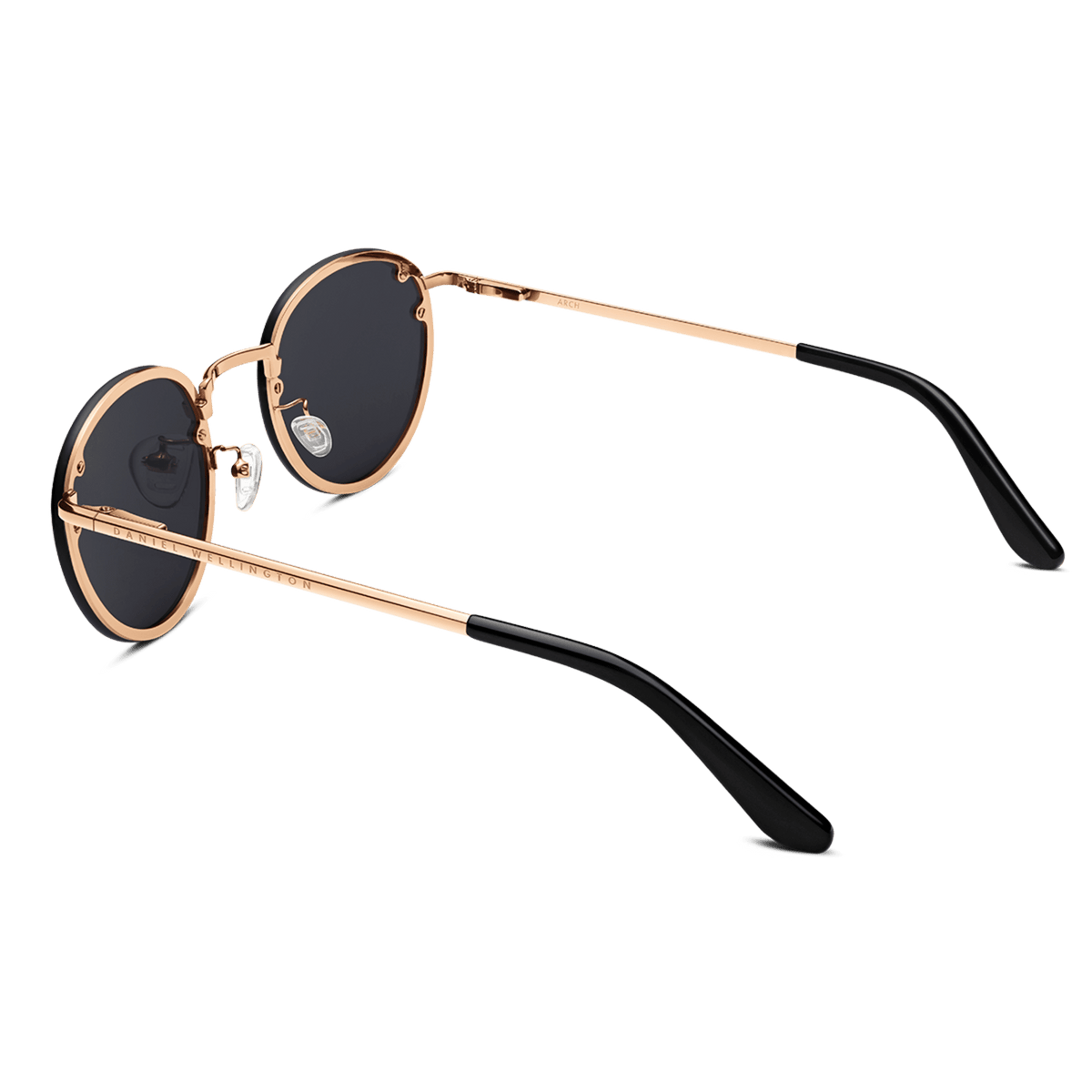 Arch Steel Black sunglasses with round dark nylon lenses, rose gold plated stainless steel frame, adjustable silicone nose pads, and black acetate temple tips, shown from an angled rear view.