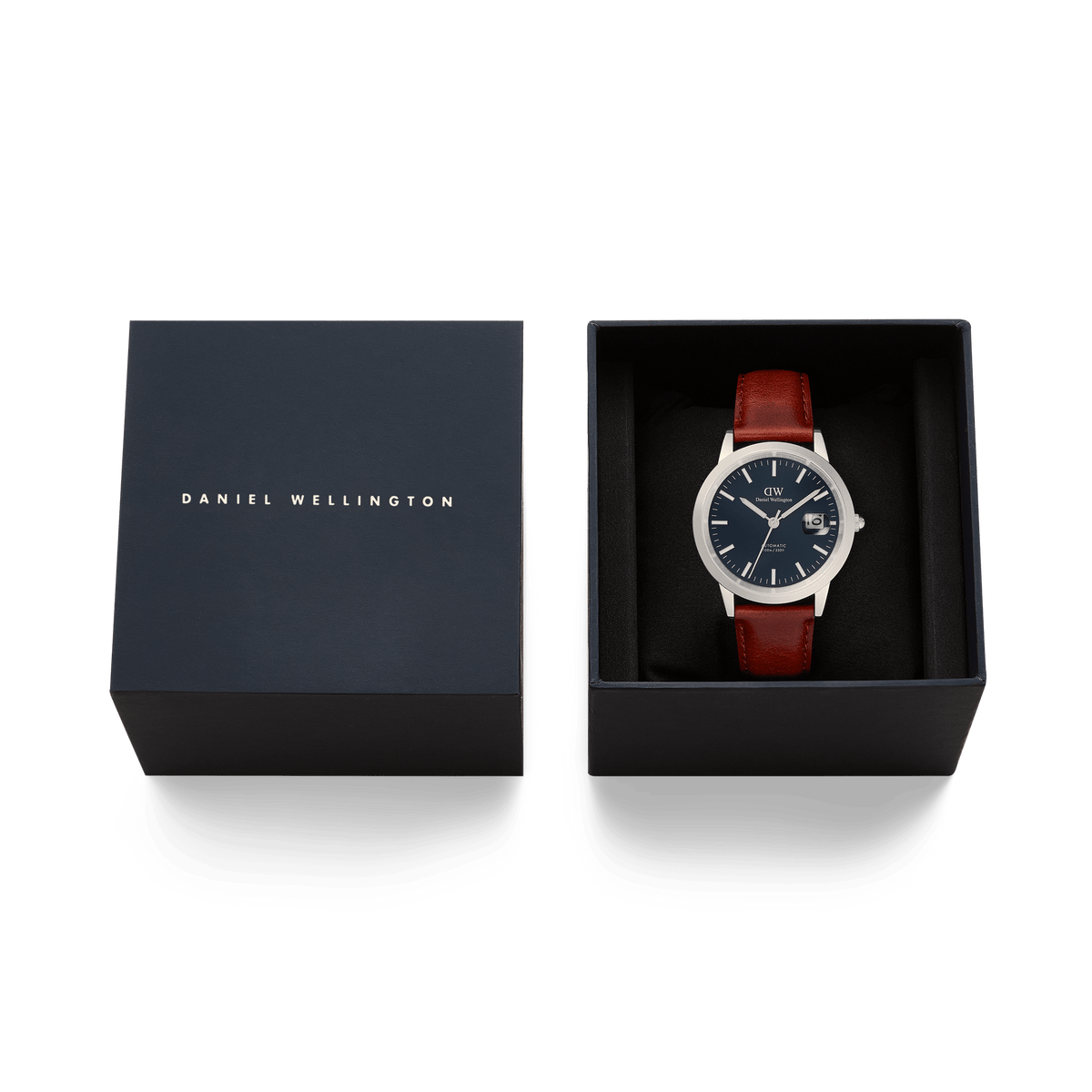 Iconic St Mawes Automatic Silver men’s watch with a brown leather strap and arctic blue enamel dial, presented in a navy Daniel Wellington gift box.