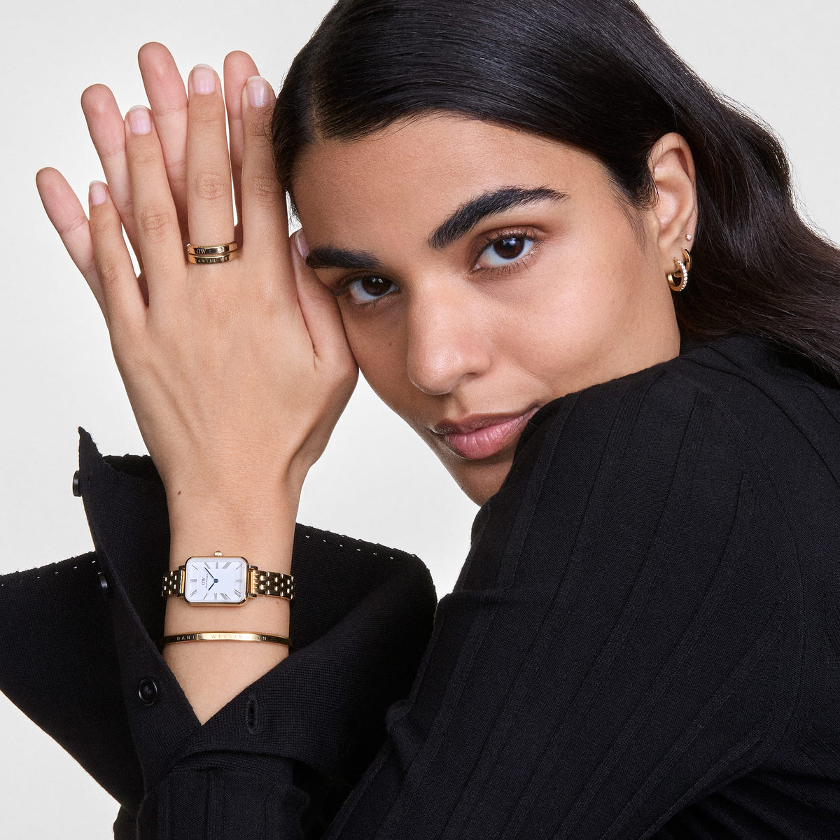 Classic Bracelet Gold styled on a wrist alongside a gold watch and matching jewellery, highlighting its slim, polished design and engraved logo as part of a modern, elegant outfit.