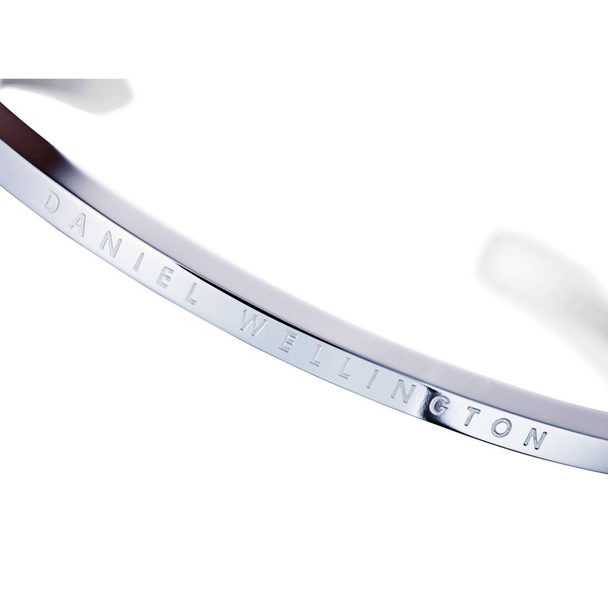 Classic Bracelet Silver by Daniel Wellington, featuring a close-up of the engraved branding on the polished stainless steel open cuff.