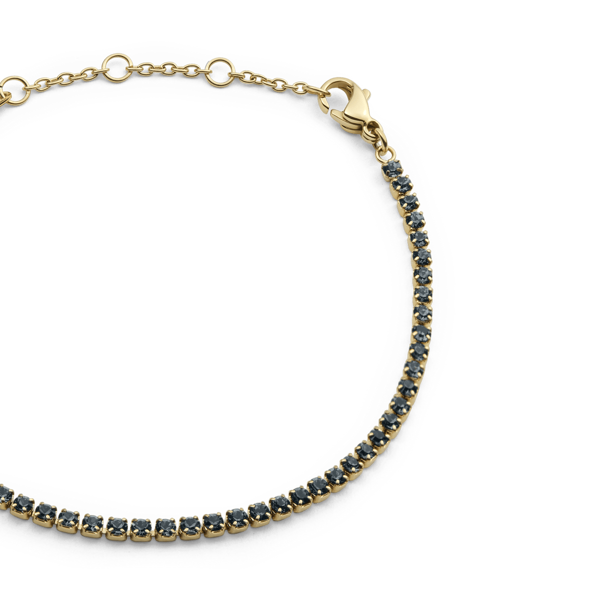 Close-up of the Classic Tennis Bracelet Nightfall Gold, showcasing its slim gold band with individually set deep-coloured Preciosa crystals and adjustable sizing rings with a lobster clasp.