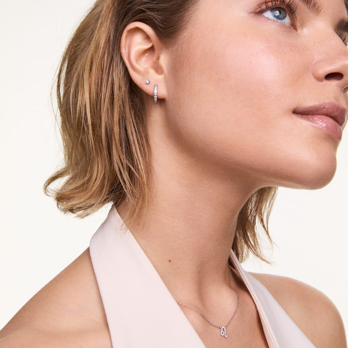 Crystal Hoop Earring Silver worn on the ear, showcasing its petite hoop shape and sparkling cubic zirconia detailing, styled with a minimalist stud and a delicate silver necklace for a polished, elegant look.