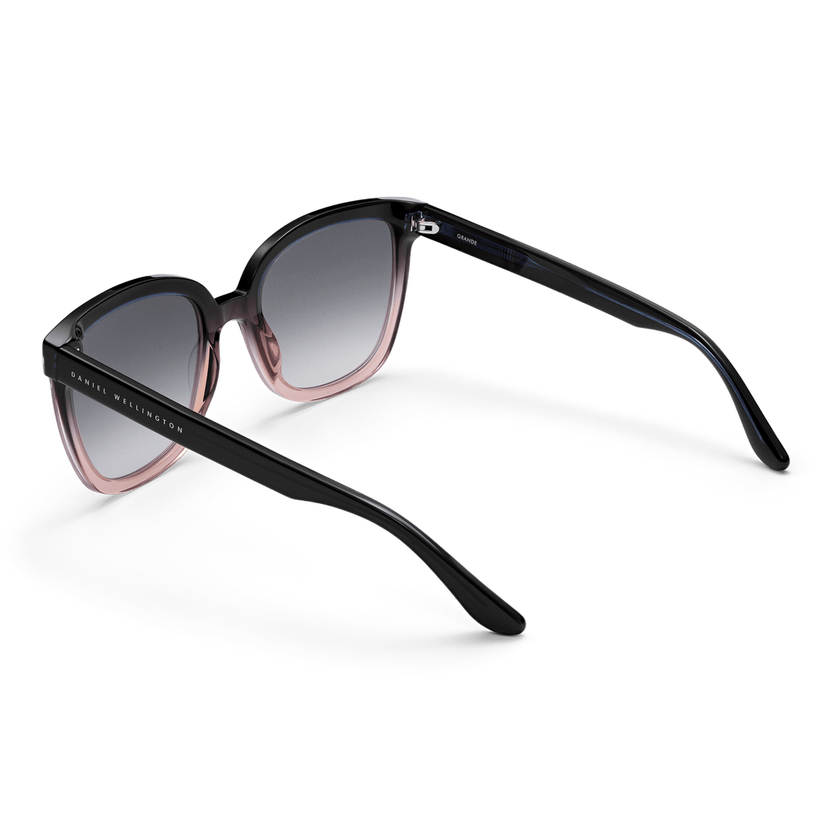 Grande Bio-Acetate Blue Coral Blue sunglasses with a bold square frame, dark blue to coral gradient detailing, black gradient lenses, and Daniel Wellington branding on the arms.