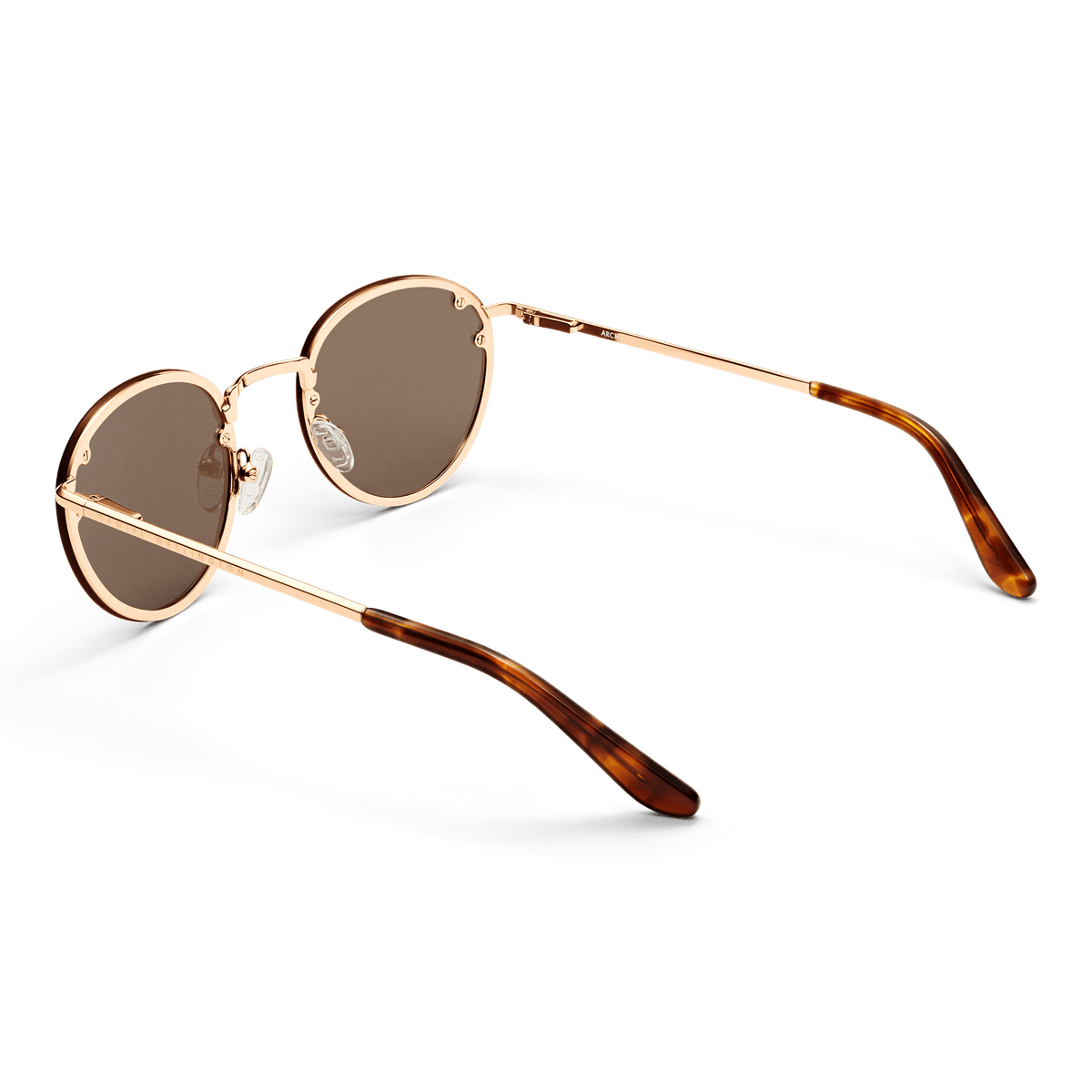 Arch Steel Brown Rose Gold sunglasses with round brown UV400 nylon lenses, rose gold plated stainless steel frame, and tortoiseshell acetate temple tips, shown from the back to highlight the slim arms and adjustable silicone nose pads.