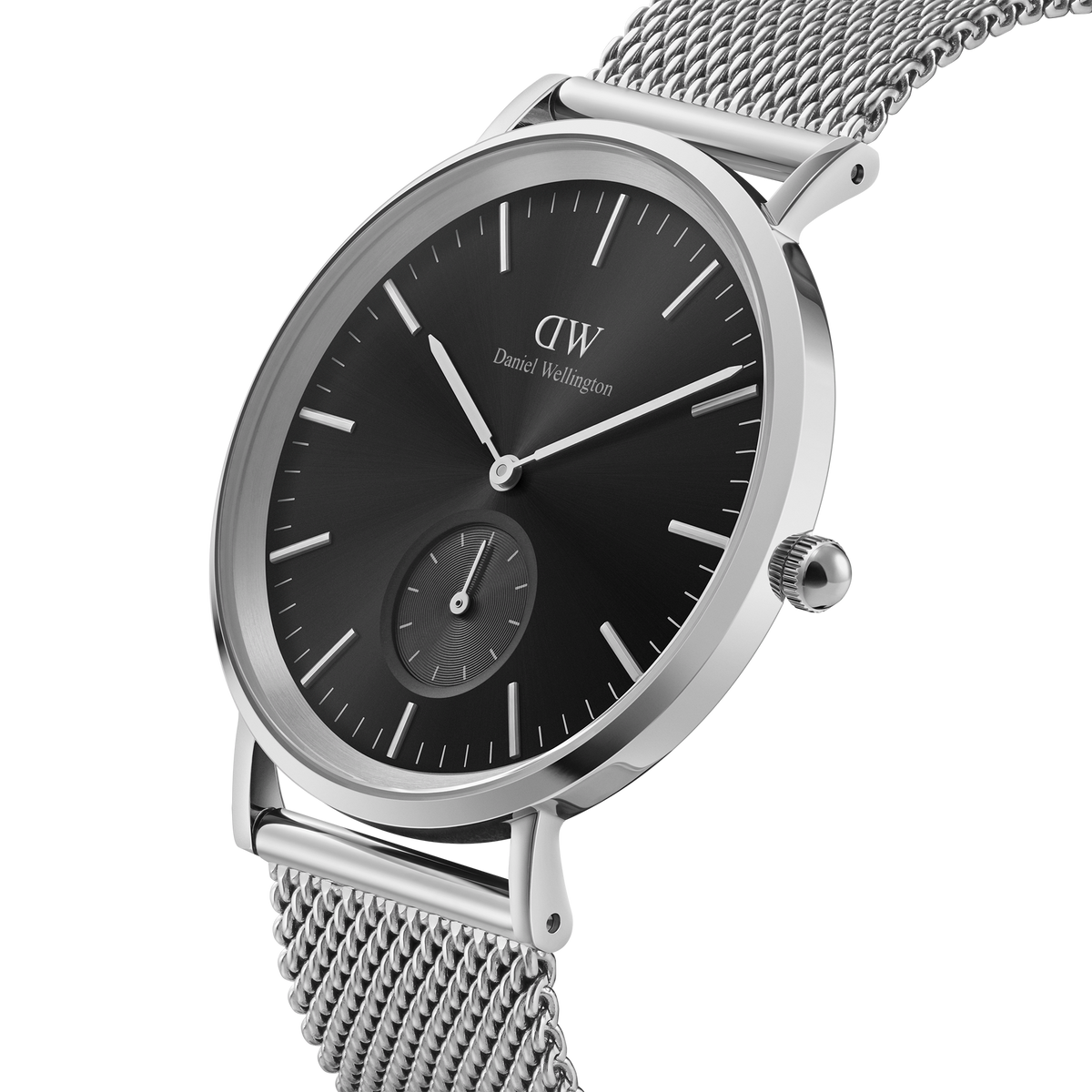 Classic Multi-Eye Sterling Onyx men's watch featuring a black dial, silver mesh strap, minimalist round case, and a seconds subdial, shown in a close-up angle highlighting its polished stainless steel finish.