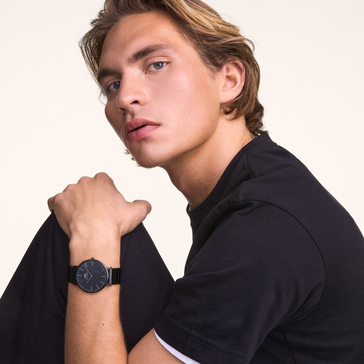 A man wearing the Classic Piano Link Graphite Unitone watch, showing its matte graphite dial and geometric piano link bracelet styled with a casual black T-shirt.
