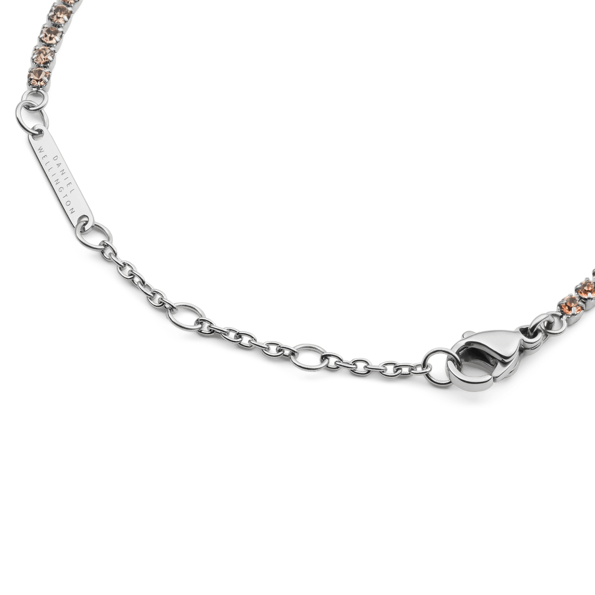 Detail of the Classic Tennis Bracelet Apricot Silver showing the adjustable sizing rings, lobster clasp, and individually set apricot-coloured crystals on a sleek silver chain.