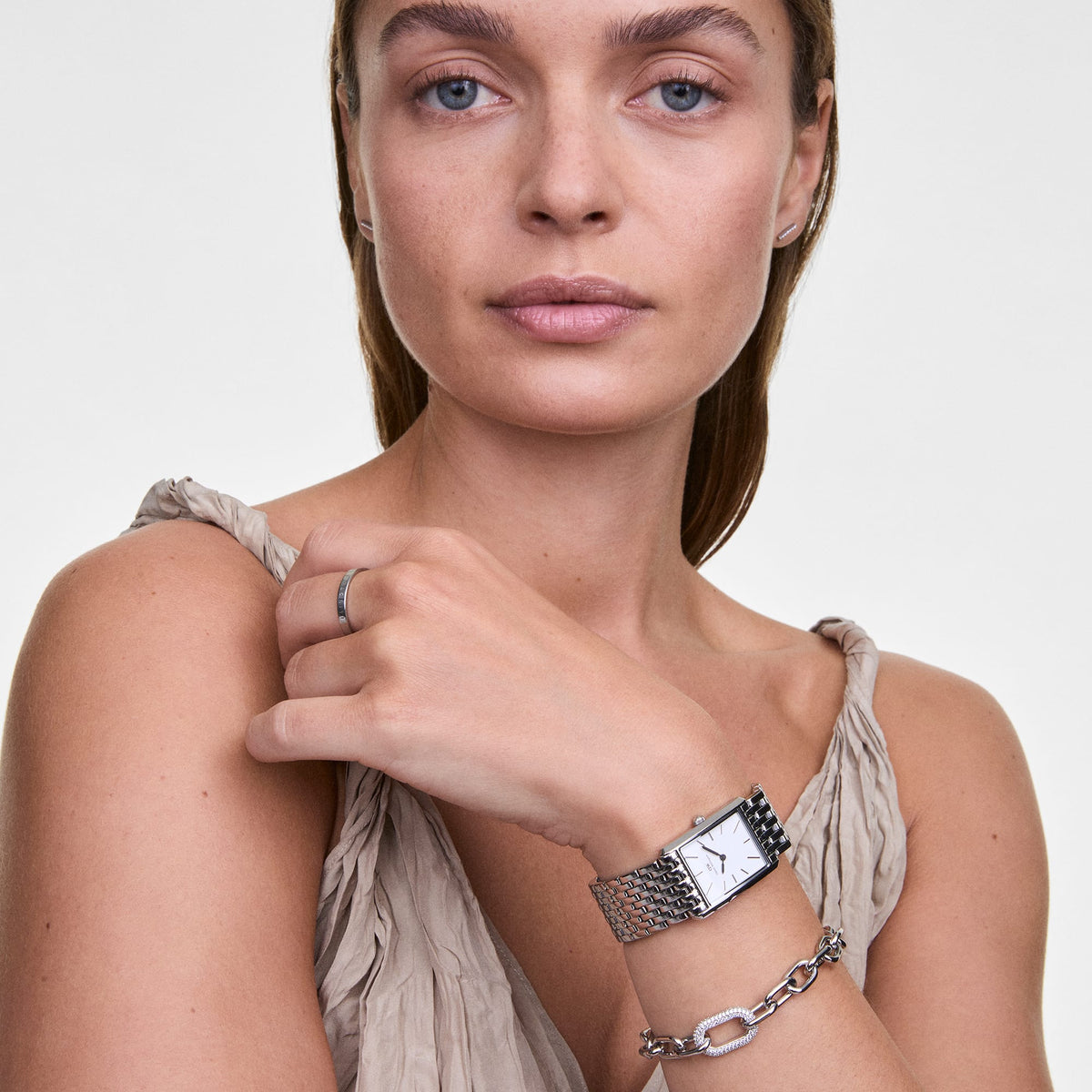 A woman wearing the Classic Ring in silver on her finger, styled with a silver watch and bracelet for a coordinated, elegant look.