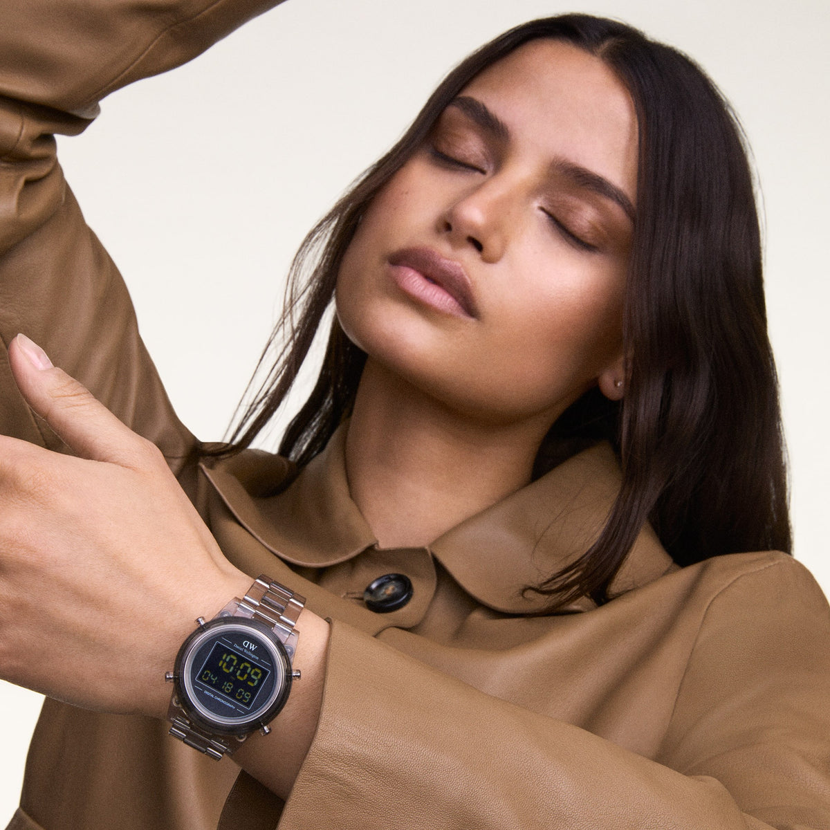 Retro Digital Light Grey Light Grey watch with a transparent light grey strap and round case, worn on the wrist with a tan coat, highlighting its contemporary style and clear digital display.