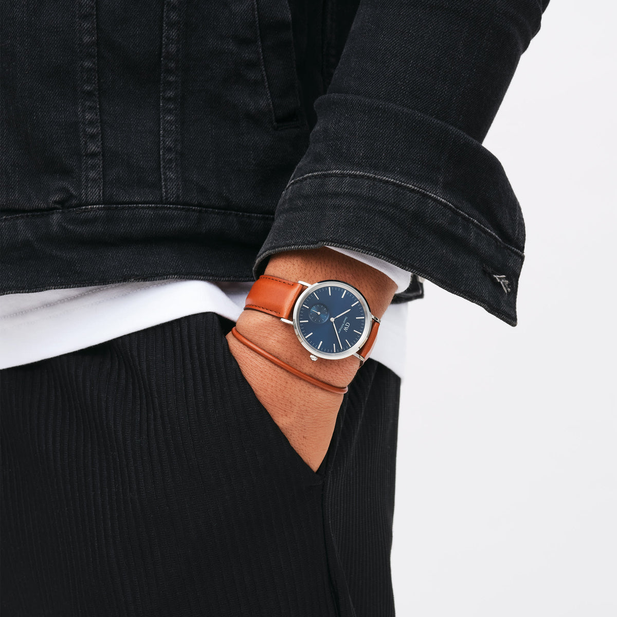 St Mawes Bracelet Silver worn on a man's wrist alongside a classic watch, styled with a black denim jacket and white shirt for a modern, everyday look.