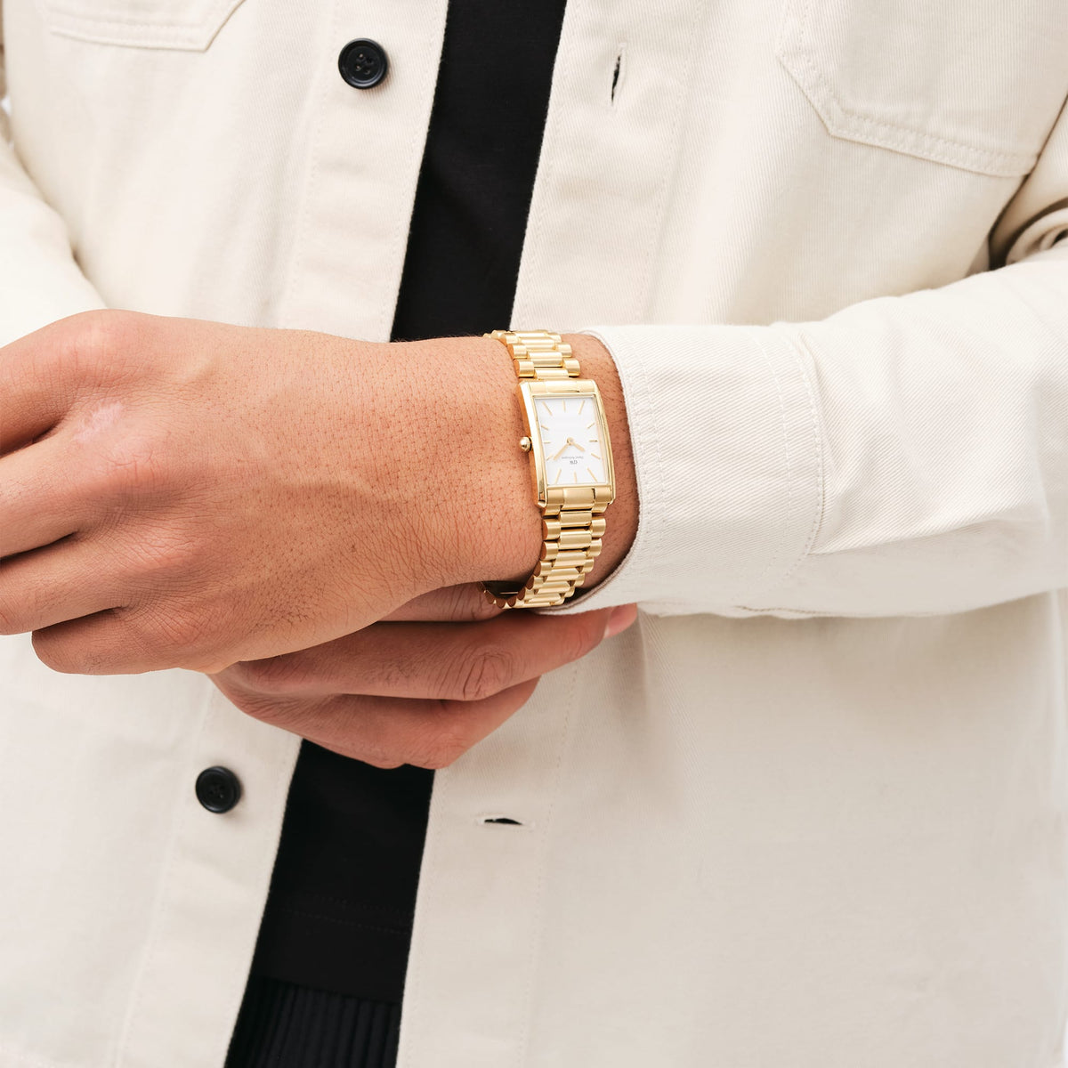 Bound 3-Link Gold wristwatch with a rectangular gold case and white dial, worn with a cream shirt for a stylish and versatile everyday look.
