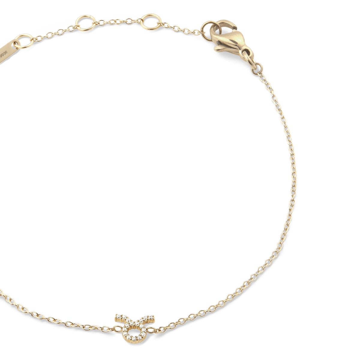 Close-up of the Crystal Zodiac Chain Bracelet Gold with a fine gold chain, adjustable sizing rings, and a crystal-encrusted Taurus zodiac charm at the centre.