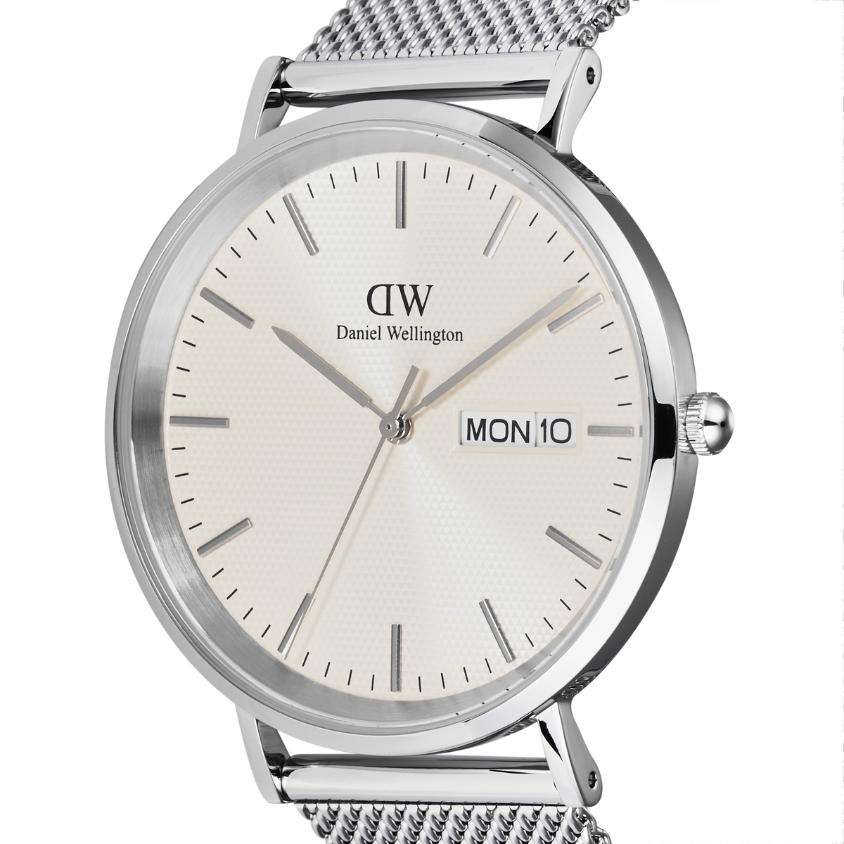 Close-up of the Classic Day Display Sterling Champagne watch showing the champagne dial with a subtle triangle pattern, silver hour markers, and a clear day and date display, paired with a stainless steel mesh strap.