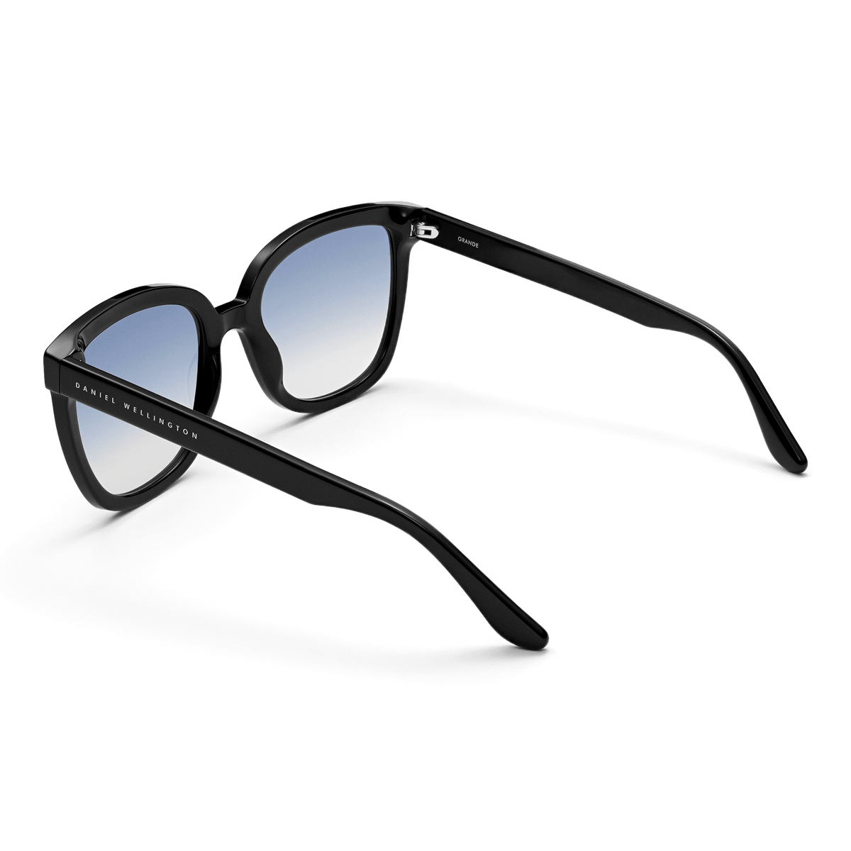 Grande Bio-Acetate Black Blue sunglasses with a classic black acetate frame, blue gradient lenses, and Daniel Wellington branding on the arm, shown from a rear angle to highlight the ergonomic fit and stylish design.