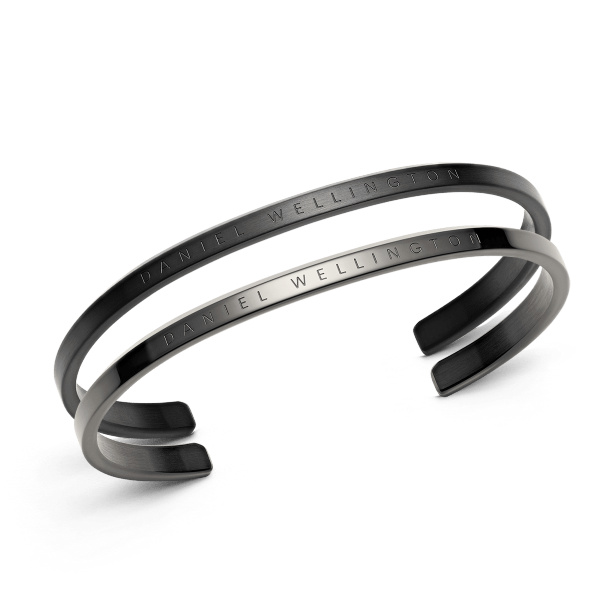 Classic Bracelet Black + Graphite set featuring two minimalist stainless steel cuff bracelets in matte black and graphite finishes, each engraved with Daniel Wellington branding.