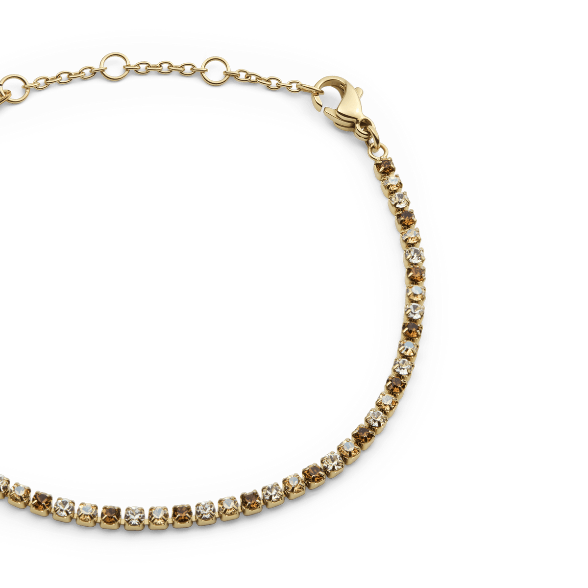 Close-up of the Classic Tennis Bracelet Honey Combo Gold showing individually set honey and clear crystals in a slim gold setting with an adjustable chain and lobster clasp.
