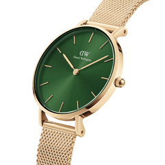 Close-up of the Petite Emerald women’s watch with a gold mesh strap, featuring a polished gold case and a deep emerald green sunray dial with minimalist gold markers.