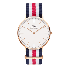 Classic Canterbury Rose Gold watch with a slim rose gold case, minimalist eggshell white dial, and a blue, white, and red striped NATO fabric strap. The design is modern and versatile, suitable for both men and women.