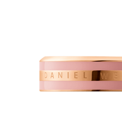 Close-up of the Emalie Ring Dusty Rose Rose Gold showing the engraved Daniel Wellington branding on a polished rose gold band with a soft pink enamel accent.