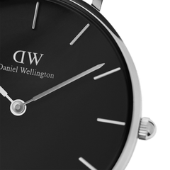 Close-up of the Petite Cornwall Black Silver watch showing the black dial, slim silver hands, minimalist hour markers, and polished silver case.