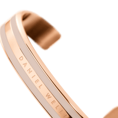 Detail view of the Emalie Bracelet Desert Sand Rose Gold, showing the rose gold and desert sand enamel finish with Daniel Wellington branding on the sleek cuff.