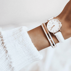 Emalie Bracelet Satin White Rose Gold worn alongside a white leather strap watch, styled with a cosy white knit jumper for a modern, elegant look.