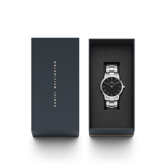The Iconic Link watch by Daniel Wellington is presented in an elegant gift box, showcasing its polished stainless steel bracelet and minimalist black dial for a refined, modern look.