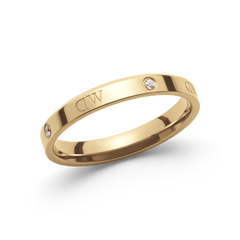 A slim gold ring with a polished finish, featuring engraved branding and sparkling crystal accents spaced evenly around the band.