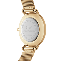 Detail of the Petite Emerald gold watch for women showing the engraved Daniel Wellington caseback, polished gold finish, and adjustable gold mesh strap.