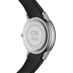 Close-up of the Daniel Wellington Iconic Motion Silver watch case back, showing the engraved branding, stainless steel construction, and black FKM rubber strap.