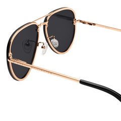 Close-up of Avion Steel Rose Gold sunglasses highlighting the rose gold plated stainless steel frame, black aviator lenses, adjustable silicone nose pads, and Daniel Wellington branding on the arm.