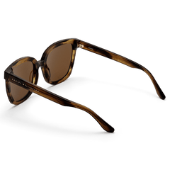 Grande Bio-Acetate Brown Demi sunglasses featuring a brown demi patterned frame, amber lenses, and Daniel Wellington branding on the temples, shown from a rear angle to highlight the lightweight construction and smooth finish.
