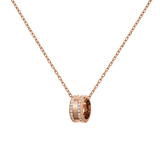Rose gold necklace featuring a round pendant with crystal accents and engraved detailing, suspended from a delicate adjustable chain.