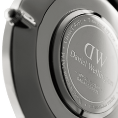 Close-up of the Classic Sheffield Silver watch case back, showing the engraved Daniel Wellington branding, water resistance rating, and unique serial number on the stainless steel surface.