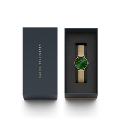 Petite Emerald gold mesh strap watch with an emerald green dial, elegantly presented in a black Daniel Wellington gift box.