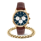 Daniel Wellington Iconic Chronograph Panda watch with a blue dial, gold accents, and brown leather strap, paired with a gold Ellipse Cuban Chain Bracelet for men.