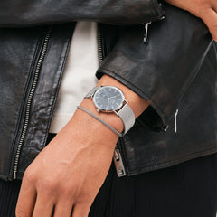 Classic Multi-Eye Sterling Onyx men's watch with a black dial and silver mesh strap, worn on the wrist alongside a silver bracelet and styled with a black leather jacket for a modern, versatile look.