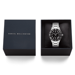 Daniel Wellington Iconic GMT Link Black Ceramic Bezel Silver watch presented in a branded gift box, featuring a stainless steel bracelet and bold black dial with ceramic bezel.