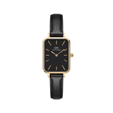 Quadro Pressed Sheffield Black Gold ladies watch featuring a rectangular gold stainless steel case, minimalist black dial with gold markers, and a slim black leather strap.