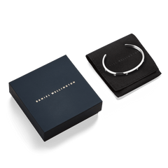 Classic Lumine Bracelet Silver 5.5mm presented in signature Daniel Wellington packaging, featuring a polished silver cuff with sparkling cubic zirconia accents on a black pouch.